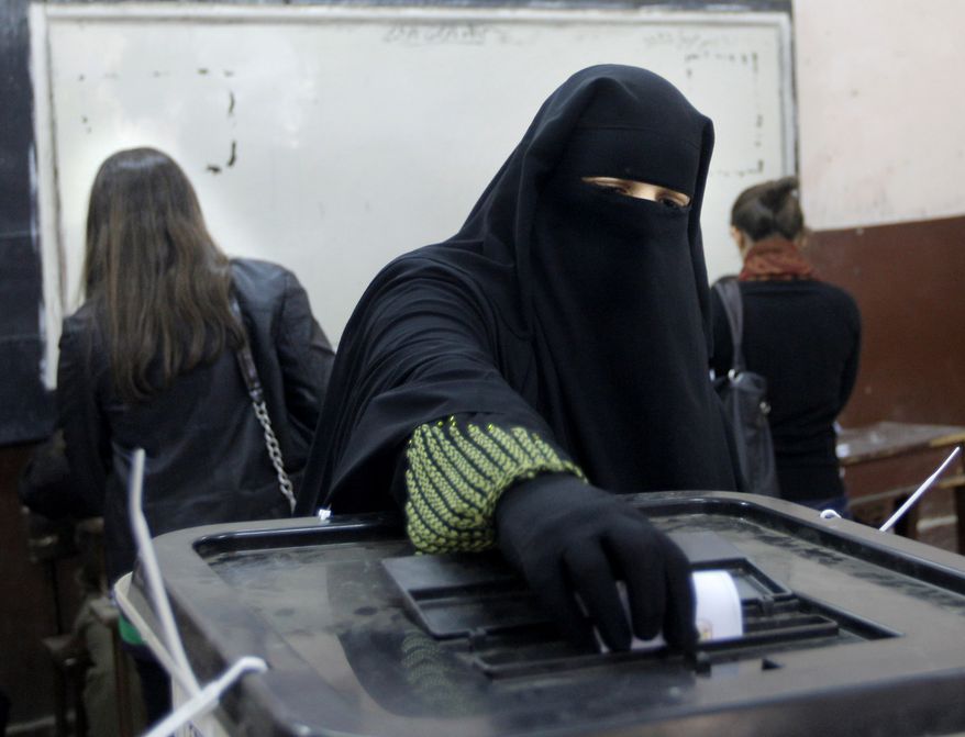 An Egyptian woman casts her vote at a polling station during a referendum on a disputed constitution drafted by Islamist supporters of President Morsi in Cairo, Egypt, Saturday, Dec. 15, 2012. Egyptians were voting on Saturday on a proposed constitution that has polarized their nation, with Morsi and his Islamist supporters backing the charter, while liberals, moderate Muslims and Christians oppose it. (AP Photo/Amr Nabil)