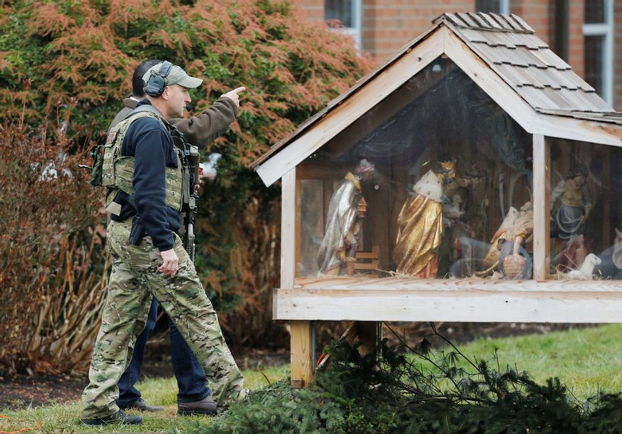 A Connecticut State Police tactical team searches the area around St. Rose of Lima Catholic Church while responding to a bomb threat, Sunday, Dec. 16, 2012, in Newtown, Conn. Worshippers hurriedly left the church Sunday, not far from where a gunman opened fire Friday inside the Sandy Hook Elementary School in Newtown. (AP Photo/Charles Krupa)