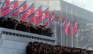 North Koreans clap near their country&#x27;s flags flown at half-staff during a reopening ceremony at the Kumsusan Palace of the Sun in Pyongyang, North Korea, on Monday, Dec. 17, 2012. North Korean officials reopened the mausoleum on the first anniversary of the death of former leader Kim Jong-il. (AP Photo/Ng Han Guan)