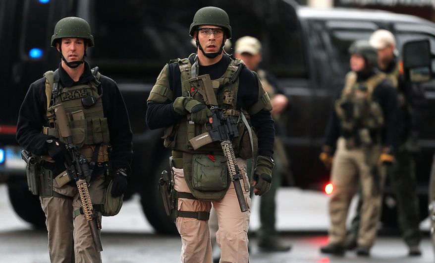 A Connecticut State Police tactical team searches a train station near an elementary school that was in a lockdown in Ridgefield, Conn., on Monday, Dec. 17, 2012, after a suspicious person was seen near the station. (AP Photo/Charles Krupa)