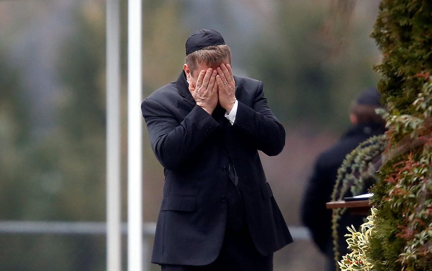A mourner arrives at the funeral service for 6-year-old Noah Pozner, Monday, Dec. 17, 2012, in Fairfield, Conn. Pozner was killed when a gunman walked into Sandy Hook Elementary School in Newtown Friday and opened fire, killing 26 people, including 20 children. (AP Photo/Jason DeCrow)