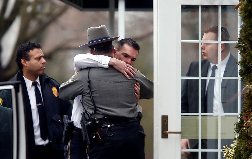 Police officers comfort one another outside a funeral service for 6-year-old Noah Pozner, Monday, Dec. 17, 2012, in Fairfield, Conn. Pozner was killed when a gunman walked into Sandy Hook Elementary School in Newtown Friday and opened fire, killing 26 people, including 20 children. (AP Photo/Jason DeCrow)