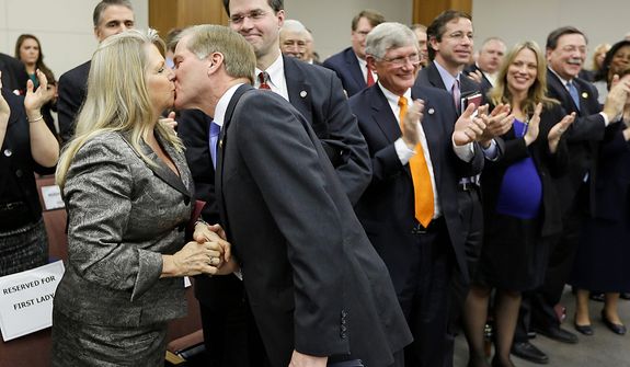 Virginia Gov. Bob McDonnell kisses his wife, Maureen, after he addressed a joint meeting of the House Appropriations and Senate Finance committees at the Capitol on Monday, Dec. 17, 2012, in Richmond. Mr. McDonnell delivered his 2013 budget proposals to the committees. (AP Photo/Steve Helber)