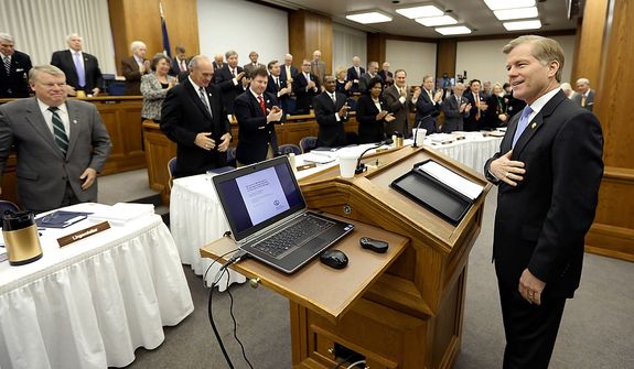 Virginia Gov. Bob McDonnell acknowledges the applause as he arrives to address a joint meeting of the House Appropriations and Senate Finance committees at the Capitol on Monday, Dec. 17, 2012, in Richmond.  Mr. McDonnell delivered his 2013 budget before the committees. (AP Photo/Steve Helber)