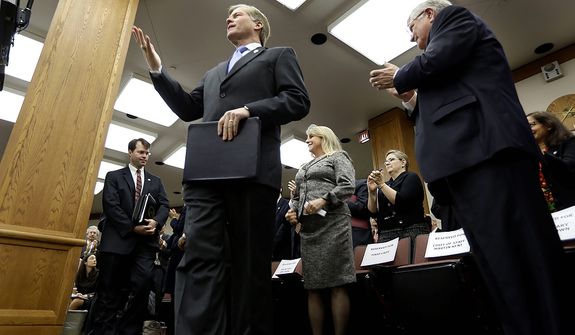 Virginia Gov. Bob McDonnell acknowledges the applause as as he arrives to address a joint meeting of the House Appropriations and Senate Finance committees at the Capitol Monday, Dec. 17, 2012 in Richmond, Va.  McDonnell delivered his 2013 budget before the committees.  (AP Photo/Steve Helber)