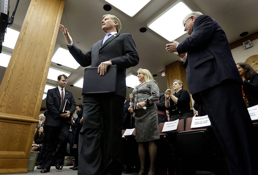 Virginia Gov. Bob McDonnell acknowledges the applause as as he arrives to address a joint meeting of the House Appropriations and Senate Finance committees at the Capitol Monday, Dec. 17, 2012 in Richmond, Va. McDonnell delivered his 2013 budget before the committees. (AP Photo/Steve Helber)