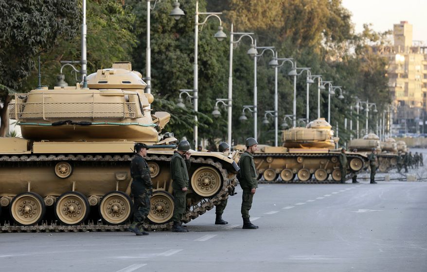 Egyptian army tanks deploy outside the presidential palace during a protest against President Mohammed Morsi in Cairo on Tuesday, Dec. 18, 2012. (AP Photo/Hassan Ammar)