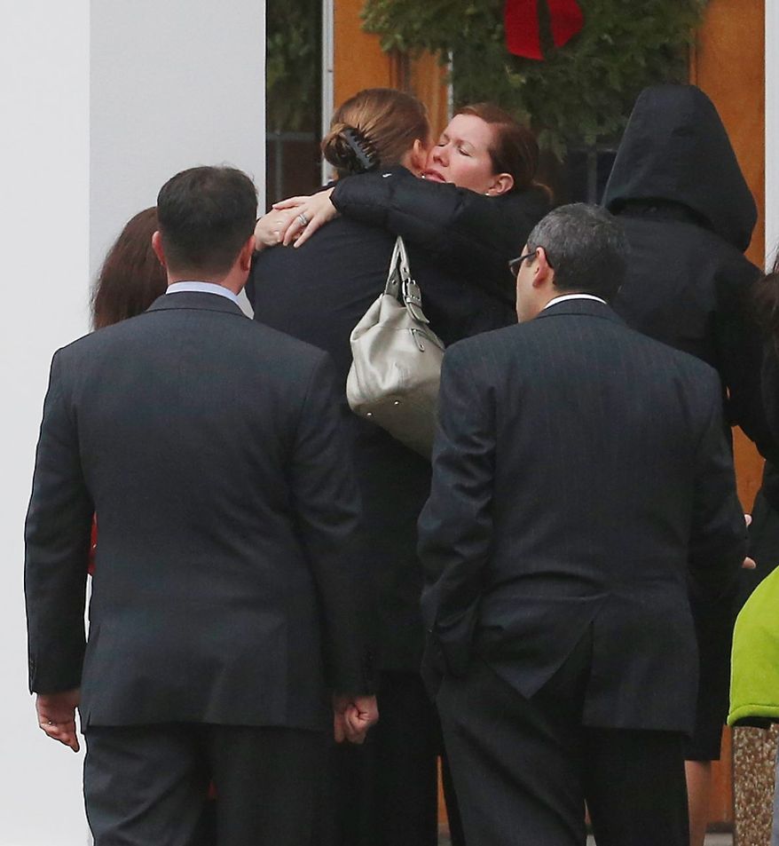 Mourners embrace outside of St. Rose of Lima Roman Catholic Church during funeral services for James Mattioli, Tuesday, Dec. 18, 2012, in Newtown, Conn. Mattioli, 6, was killed when Adam Lanza walked into Sandy Hook Elementary School in Newtown, Conn., Dec. 14, and opened fire, killing 26 people, including 20 children, before killing himself. (AP Photo/Julio Cortez)