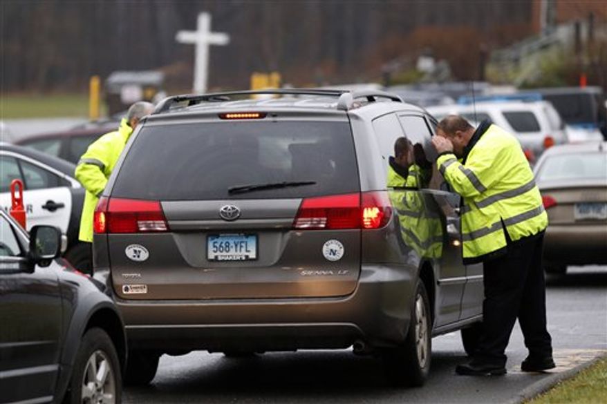 A police officer inspects a vehicle arriving at St. Rose of Lima Roman Catholic Church before funeral services for James Mattioli, a boy killed in an elementary school shooting, Tuesday, Dec. 18, 2012, in Newtown, Conn. Mattioli, 6, was killed when Adam Lanza walked into Sandy Hook Elementary School in Newtown, Conn., Dec. 14, and opened fire, killing 26 people, including 20 children, before killing himself. (AP Photo/Julio Cortez)