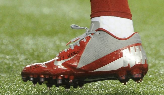 in this Sunday, Dec. 16, 2012, photo, a shoe worn by New York Giants wide receiver Victor Cruz bears a message dedicated to 6-year-old Jack Pinto, one of the victims in last week&#x27;s school shootings at Sandy Hook Elementary School in Newtown, Conn., as Cruz warms up for the Giants&#x27; NFL football game against the Atlanta Falcons in Atlanta. (AP Photo/John Amis)