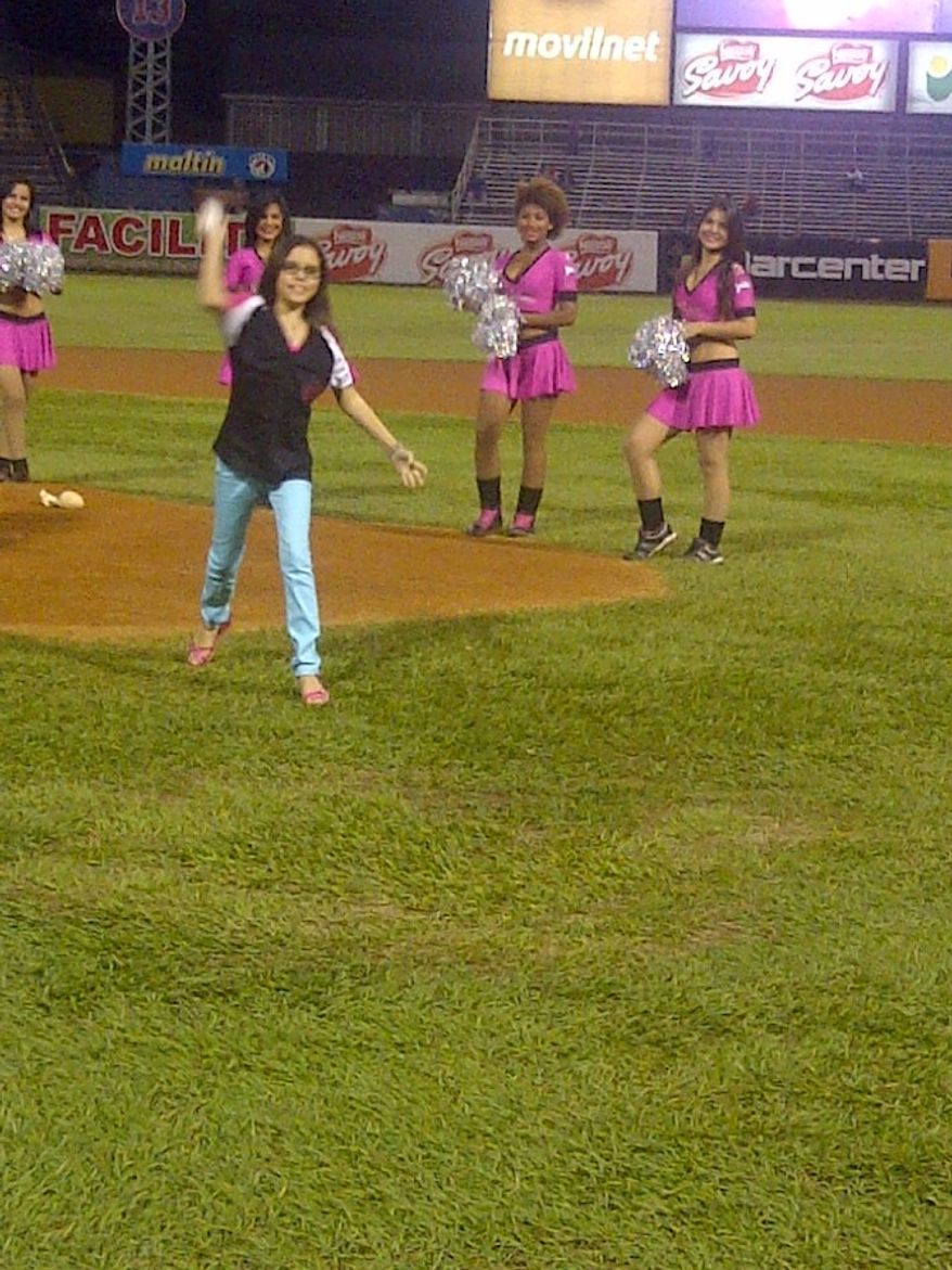 Victoria Cabrera, recovered now from major heart surgery in late August, throws out the first pitch for the Tigres de Aragua in Venezuela on Monday. Washington Nationals catcher Wilson Ramos helped Cabrera and her mother, Marfa Mata, raise the money for her surgery. (Photo courtesy of Marfa Mata)