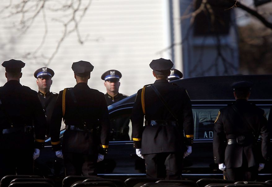 A hearse bearing the body of Victoria Soto drives past a police honor guard as it arrives for her funeral service at Lordship Community Church, Wednesday, Dec. 19, 2012, in Stratford, Conn. Soto was killed when a gunman forced his way into Sandy Hook Elementary School in Newtown Dec. 14, and opened fire, killing 26 people, including 20 children. (AP Photo/Jason DeCrow)