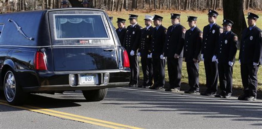 Firefighters stand as the procession heads to the cemetery outside the funeral for school shooting victim Daniel Gerard Barden at St. Rose of Lima Catholic Church in Newtown, Conn., Wednesday, Dec. 19, 2012. According to firefighters, Daniel wanted to be a firefighter when he grew up and they honored him at the service. Barden, 7, was killed when Adam Lanza walked into Sandy Hook Elementary School in Newtown, Conn., Dec. 14, and opened fire, killing 26 people, including 20 children, before killing himself. (AP Photo/Charles Krupa)