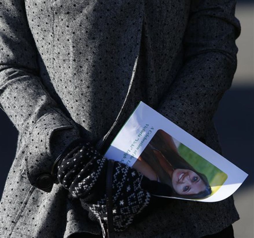 A mourner carries a program as she leaves the funeral service of Victoria Soto at Lordship Community Church, Wednesday, Dec. 19, 2012, in Stratford, Conn. Soto was killed when Adam Lanza walked into Sandy Hook Elementary School in Newtown, Conn., Dec. 14, and opened fire, killing 26 people, including 20 children, before killing himself. (AP Photo/Jason DeCrow)