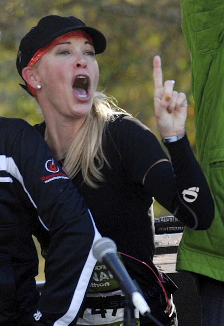 FILE - In this Nov. 3, 2012, file photo, Suzy Favor Hamilton, second from right, a former U.S. Olympian, dances on the stage at the finish line after competing in the Rock 'n' Roll Half Marathon in Savannah, Ga. The three-time Olympian has admitted leading a double life as an escort. She apologized Thursday, Dec. 20, 2012, after a report by The Smoking Gun website said she had been working as a prostitute in Las Vegas. (AP Photo/Savannah Morning News, Richard Burkhart)