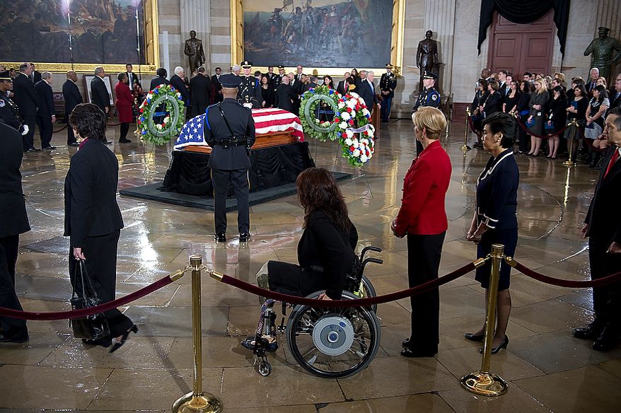People, including U.S. Rep.-elect Tammy Duckworth, center, in the wheelchair, file past the casket of the late Sen. Daniel Inouye following a memorial service in the U.S. Capitol rotunda on Thursday, Dec. 20, 2012. Sen. Inouye, who served as a U.S. senator for 50 years, is only the 31st person to lie in state in the rotunda of the U.S. Capitol. It is seen as a sign of respect. (Barbara L. Salisbury/The Washington Times)