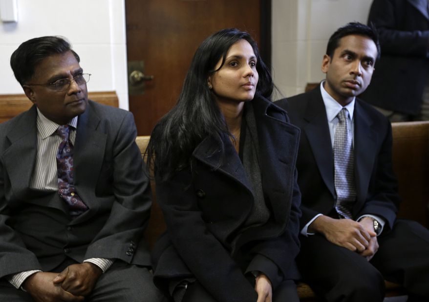 Annie Dookhan (center) sits between two unidentified men in Suffolk Superior Court in Boston moments before her arraignment on Thursday, Dec. 20, 2012. Ms. Dookhan, the former chemist at the center of a drug-testing scandal, pleaded not guilty to charges including perjury and tampering with evidence. (AP Photo/Steven Senne, Pool)