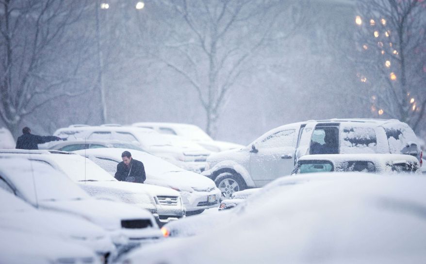 Mutual of Omaha employees clean their vehicles of snow before leaving on their drive home during the evening commute Wednesday Dec. 20, 2012, in Omaha Neb. A storm that has dumped more than a foot of snow in the Rocky Mountains is heading east and is forecast to bring the first major winter storm of the season to the central plains and Midwest. (AP Photo/The World-Herald, Matt Miller)