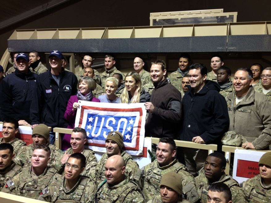Capitals forward Matt Hendricks (center, holding banner) and Nationals pitchers Craig Stammen and Ross Detwiler, pose with troops at the transit center in Manas, Kyrgyzstan during their USO Tour in December. (Photo courtesy Matt Hendricks)