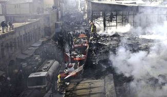 Policemen and firefighters investigate the scene of a burning market in Kabul, Afghanistan, on Sunday, Dec. 23, 2012. Hundreds of shops at a market were damaged in the blaze, but no causalities were reported. (AP Photo/Musadeq Sadeq)