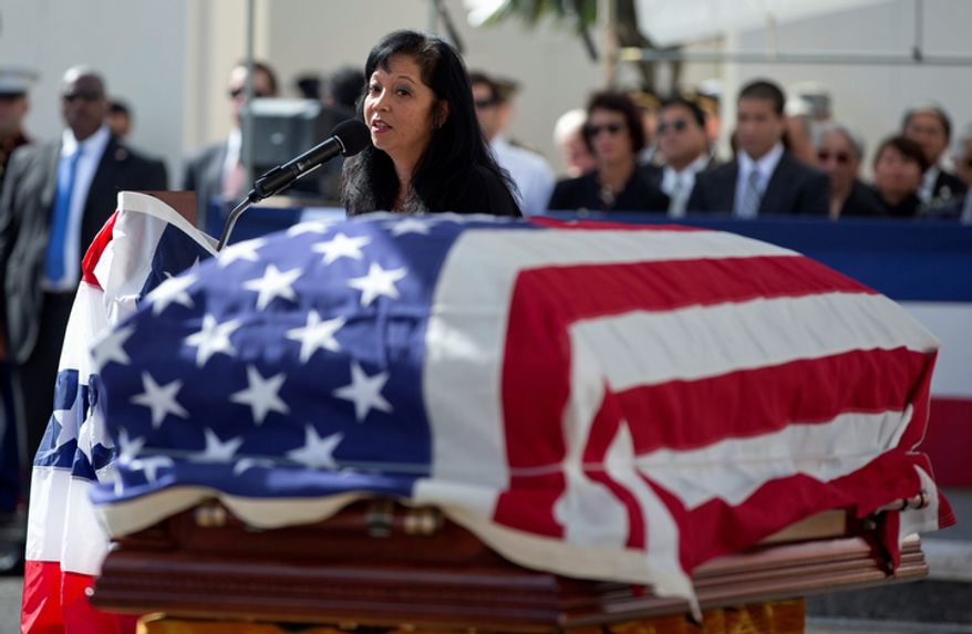 Jennifer Sabas, chief of staff for the late Sen. Daniel Inouye, D-Hawaii, looks toward his flag-draped casket during a memorial service at the National Memorial Cemetery of the Pacific, Sunday, Dec. 23, 2012, in Honolulu. Inouye, 88, was the first Japanese-American elected to both houses of Congress and the second-longest serving senator in U.S. history. He died Dec. 17. (AP Photo/Carolyn Kaster)