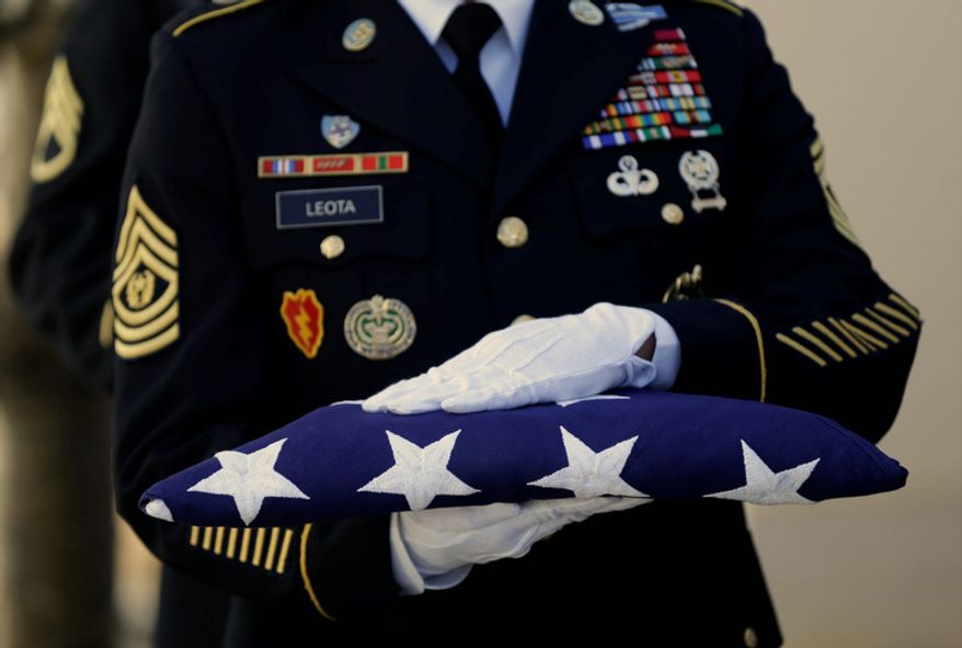 An honor guard holds a flag to be given to family members during the Memorial Service for Sen. Daniel Inouye, D-Hawaii, at the Punchbowl National Memorial Cemetery of the Pacific in Honolulu, Sunday, Dec. 23, 2012. (AP Photo/Gerald Herbert)