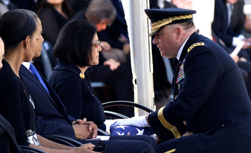 Lt. Gen. Francis Wiercinski, commander of the U.S. Army Pacific, presents an American flag to Irene Hirano Inouye, widow of Sen. Daniel Inouye, D-Hawaii, as she sits with President Barack Obama and first Lady Michelle Obama, left, during the memorial service for the late senator at the Punchbowl National Memorial Cemetery of the Pacific in Honolulu, Sunday, Dec. 23, 2012. Inouye, the first Japanese-American elected to both houses of Congress, died Dec. 17 at age 88. (AP Photo/Gerald Herbert)
