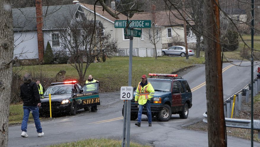 Emergency responders block Juniata Valley Road on Friday, Dec. 21, 2012, in Geeseytown, Pa., after a man fatally shot a woman decorating for a children's Christmas party at a tiny church hall and killed two men elsewhere in the rural central Pennsylvania township before he was fatally shot in a gunfight with state troopers. (AP Photo/Keith Srakocic)