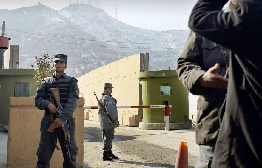 Afghan police stand guard at Kabul police headquarters, where a U.S. civilian adviser was killed by an Afghan policewoman who shot him once in the chest. (Associated Press)