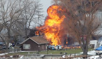 A house burns Monday in Webster, N.Y., a suburb of Rochester on Lake Ontario. A 62-year-old ex-convict set a car and a house ablaze in the neighborhood to lure firefighters before opening fire on them, slaying two. (Associated Press)