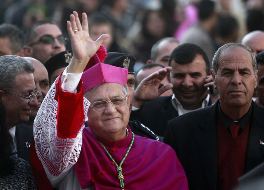 Latin Patriarch of Jerusalem Fouad Twal waves to the crowds before Christmas celebrations in the West Bank town of Bethlehem, Monday, Dec. 24, 2012. (AP Photo/Adel Hana)