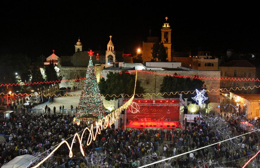 Christian worshippers and tourists celebrate at the Manger Square in front of the Church of the Nativity, in the West Bank town of Bethlehem, Monday, Dec. 24, 2012. Thousands of Christian worshippers and tourists arrived in Bethlehem on Monday to mark Christmas at the site where many believe Jesus Christ was born. (AP Photo/Adel Hana)