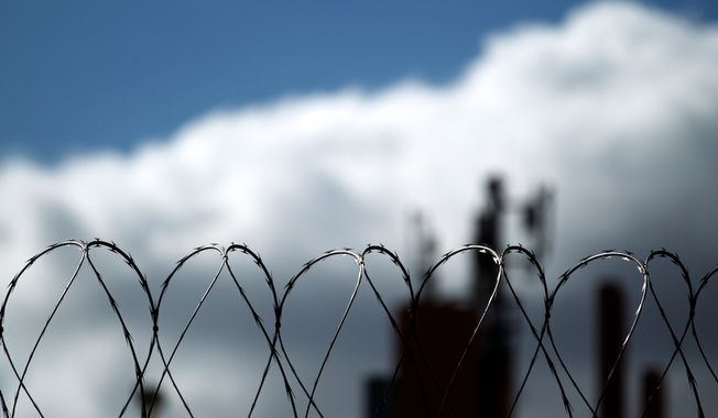 Razor wire sits atop a border fence as a building in the Mexican border city of Tijuana sits behind, as seen from San Diego on Monday, Jan. 31, 2011. (AP Photo/Gregory Bull) ** FILE **