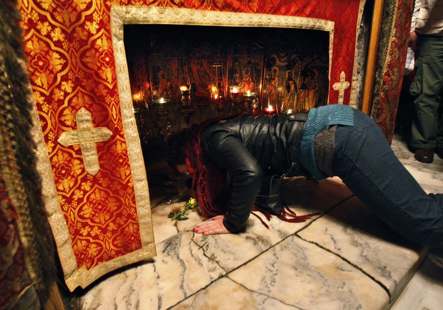 A Christian worshipper prays inside the Grotto at the Church of the Nativity, traditionally believed by Christians to be the birthplace of Jesus Christ, in the West Bank town of Bethlehem on Monday, Dec. 24, 2012. (AP Photo/Adel Hana)