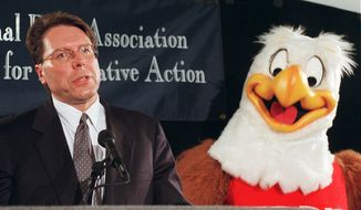 National Rifle Association gun-safety mascot Eddie Eagle stands beside Wayne LaPierre, NRA executive vice president and CEO, during a news conference in Washington on Friday, Feb. 28, 1997, to mark the third anniversary of the Brady Act. (AP Photo/Dennis Cook)