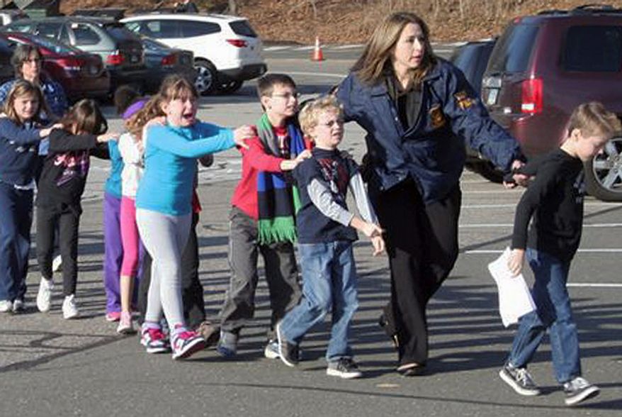 Connecticut State Police lead children from the Sandy Hook Elementary School in Newtown, Conn., following the shooting there on Friday, Dec. 14, 2012. (AP Photo/Newtown Bee, Shannon Hicks)