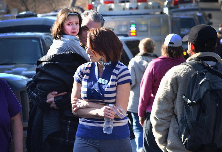 A young girl is comforted following the mass shooting at the Sandy Hook Elementary School in Newtown, Conn., about 60 miles northeast of New York, on Friday, Dec. 14, 2012. (AP Photo/The New Haven Register, Melanie Stengel)