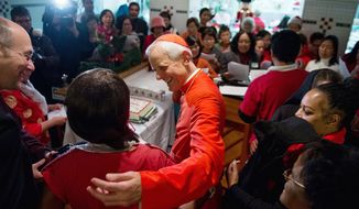 The Catholic archbishop of Washington, Cardinal Donald W. Wuerl, greets the choir as meals are provided to church attendees after Mass on Christmas Day at the Basilica of the National Shrine of the Immaculate Conception in Washington. (Andrew Harnik/The Washington Times)