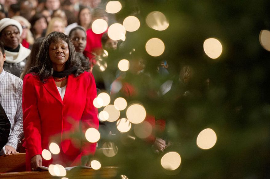 A church attendant closes her eyes in prayer as Cardinal Donald Wuerl, archbishop of Washington, celebrates the Solemn Mass of Christmas Day at the Basilica of the National Shrine of the Immaculate Conception in Washington on Tuesday, Dec. 25, 2012. (Andrew Harnik/The Washington Times)