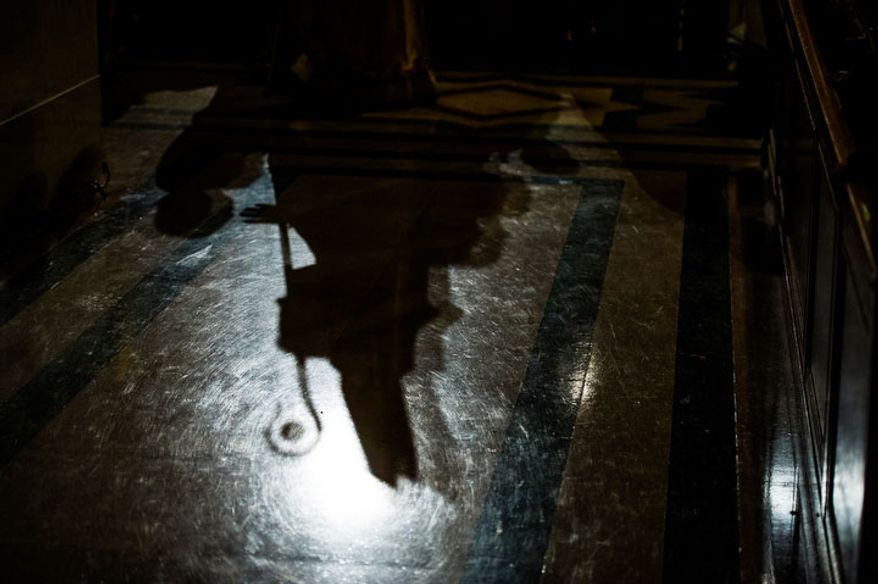 The shadow of Archbishop of Washington Cardinal Donald Wuerl can be seen as he joins a processional for the Solemn Mass of Christmas Day at the Basilica of the National Shrine of the Immaculate Conception, Washington, D.C., Tuesday, December 25, 2012. (Andrew Harnik/The Washington Times)