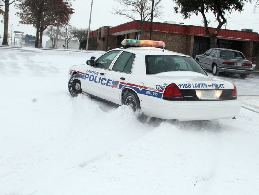 A Lawton, Okla., police cruiser tries to navigate the snow as blizzard conditions hit southwest Oklahoma at midday Tuesday, Dec. 25, 2012. (AP Photo/The Lawton Constitution, Brandon Neris)
