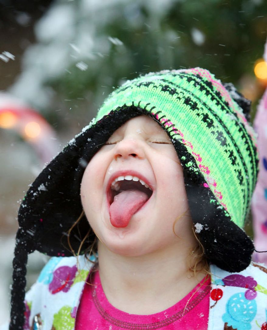 Iris Davis sticks her tongue out trying to catch snowflakes Tuesday, Dec. 25, 2012 after a strong winter system dropped inches of rain and snow on most of North East Texas. (AP Photo / The Paris News, Sam Craft)