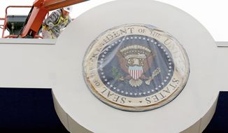 A painter touches up the presidential viewing stand in front of the White House in Washington on Thursday, Dec. 20, 2012, as preparations continue for the Inauguration on Monday, Jan. 21, 2013. (AP Photo/J. David Ake)