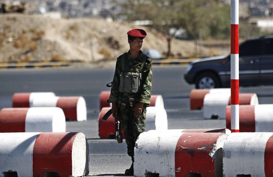 A Yemeni soldier stands guard at a street leading to the presidential palace in Sanaa, Yemen, on Tuesday, Dec. 25, 2012. Gunmen on motorbikes assassinated two Yemeni army officers in Sanaa, the capital, while clashes between the military and tribal fighters loyal to al Qaeda in a northeastern province killed three soldiers and several tribesmen, officials said. (AP Photo/Hani Mohammed)