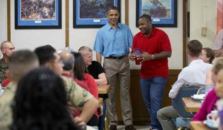 President Barack Obama visits with members of the military and their families in Anderson Hall at Marine Corp Base Hawaii, Tuesday, Dec. 25, 2012, in Kaneohe Bay, Hawaii. The first family is in Hawaii for a holiday vacation. (AP Photo/Carolyn Kaster)