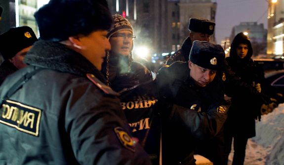 Russian police officers detain a protester outside the Federation Council on Dec. 26, 2012. Several protesters were detained that morning outside the upper chamber of Russia&#39;s parliament, which is set to vote on a measure banning Americans from adopting Russian children. (Associated Press)