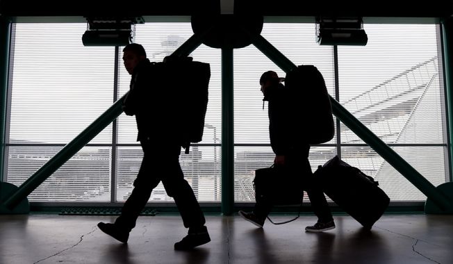**FILE** Travelers walk to a ticketing desk at O'Hare International Airport in Chicago on Dec. 21, 2012. (Associated Press)
