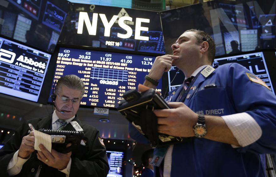 Daniel Kryger (left) and Kevin Lodewick Jr. follow trading from the floor of the New York Stock Exchange in New York on Dec. 26, 2012. (Associated Press)