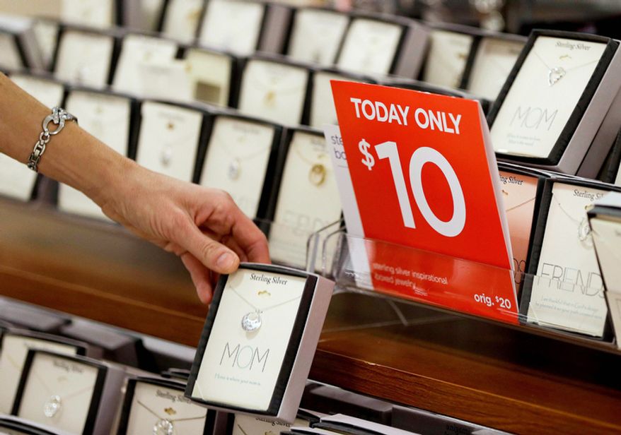 In this Friday, Nov. 23, 2012 photo, a woman browses through a display of jewelry on sale at a J.C. Penney store in Las Vegas. In the midst of the busy holiday shopping season, when retailers can make up to 40 percent of their sales, promotions are actually down 5 percent year over year so far, according to BMO Capital market's sales rack index. (AP Photo/Julie Jacobson)