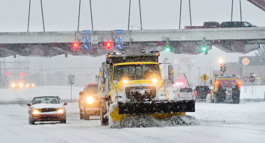 A Indiana State Highway Garage snow plows moves work along Jonathan Moore Pike in Columbus, Ind. Wednesday Dec. 26, 2012. The blizzard warning issued the day before by National Weather Service came to fruition in the region as winds picked up and snow began falling in earnest before dawn. (AP Photo/The Republic, Joe Harpring)